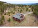Beautiful aerial view of a mountain home featuring rustic wood siding and stunning forest views at 76 Raven Ridge Rd, Idaho Springs, CO 80452