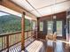 Covered deck with porch swing and views of the surrounding evergreen forest at 76 Raven Ridge Rd, Idaho Springs, CO 80452