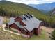 Beautiful exterior view of a mountain home featuring rustic wood siding and stunning views of the forest at 76 Raven Ridge Rd, Idaho Springs, CO 80452