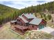 A beautiful view of a mountain home featuring a large deck with forest views at 76 Raven Ridge Rd, Idaho Springs, CO 80452