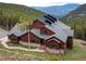 An exterior elevation showing the home with a stone foundation and solar panels at 76 Raven Ridge Rd, Idaho Springs, CO 80452