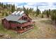 A mountain home featuring a large deck for outdoor living, is nestled in a forest setting at 76 Raven Ridge Rd, Idaho Springs, CO 80452