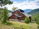 Beautiful exterior view of a mountain home featuring rustic wood siding and stunning views of the forest at 76 Raven Ridge Rd, Idaho Springs, CO 80452