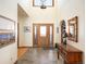 Inviting foyer with tile flooring, a wooden front door, and a decorative console table with mirror at 76 Raven Ridge Rd, Idaho Springs, CO 80452