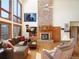 Bright living room with stone fireplace, high windows with mountain views, and hardwood floors at 76 Raven Ridge Rd, Idaho Springs, CO 80452