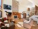 Cozy living room with stone fireplace, high windows with mountain views, and hardwood floors at 76 Raven Ridge Rd, Idaho Springs, CO 80452