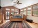Bright primary bedroom featuring a wood-framed bed, vaulted ceiling, large windows, and views of the mountains at 76 Raven Ridge Rd, Idaho Springs, CO 80452