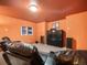 A comfy theater room featuring leather recliners, TV, and orange walls at 76 Raven Ridge Rd, Idaho Springs, CO 80452