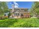 Expansive backyard featuring a well-maintained lawn, wooden deck, and mature trees perfect for outdoor enjoyment at 2141 Weatherstone Cir, Highlands Ranch, CO 80126