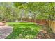 Landscaped backyard with a wooden fence, brick patio, and lush lawn at 2141 Weatherstone Cir, Highlands Ranch, CO 80126