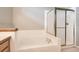 Bathroom featuring a tiled bathtub, shower with sliding doors, and neutral paint at 2141 Weatherstone Cir, Highlands Ranch, CO 80126