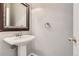 Powder room featuring a white pedestal sink, decorative mirror, and modern fixtures at 2141 Weatherstone Cir, Highlands Ranch, CO 80126