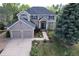Two-story home showcasing a well-manicured front yard, two-car garage, and inviting entryway at 2141 Weatherstone Cir, Highlands Ranch, CO 80126