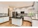 Modern kitchen with white cabinets, stainless steel appliances, island, and hardwood flooring at 2141 Weatherstone Cir, Highlands Ranch, CO 80126