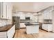 Bright kitchen featuring white cabinets, stainless steel appliances, granite counters, and hardwood floors at 2141 Weatherstone Cir, Highlands Ranch, CO 80126