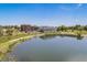 Scenic aerial view of complex by lake featuring clear blue sky, walking path, and lush green landscaping at 3047 W 47Th Ave # 109, Denver, CO 80211