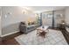 Inviting living room features a grey sofa, area rug, wood floors and natural light at 3047 W 47Th Ave # 109, Denver, CO 80211