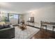 Bright living room with wood floors, area rug, grey sofa and view from the window at 3047 W 47Th Ave # 109, Denver, CO 80211