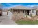 View of the home and detached garage showcasing the home's side entrance and manicured lawn at 2307 Moline St, Aurora, CO 80010