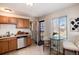 The kitchen has light wood cabinets, a small dining table and a view into the laundry room at 2307 Moline St, Aurora, CO 80010