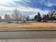 Open green space with mature trees and distant buildings at 12423 E Louisiana Ave, Aurora, CO 80012