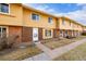 Row of tan brick townhouses with attached garages and a grassy area at 12423 E Louisiana Ave, Aurora, CO 80012