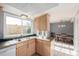 Kitchen with light wood cabinets, a peninsula, and access to a dining area at 12423 E Louisiana Ave, Aurora, CO 80012