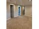 Open living room with multiple doorways, recessed ceiling lights, and tan carpeting at 3566 E Fair Pl, Centennial, CO 80121