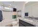 Updated bathroom with granite counters, tiled shower with curtain, and modern fixtures at 6233 N Liverpool St, Aurora, CO 80019
