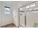 Modern bathroom featuring a glass-enclosed shower with decorative tile and window at 6233 N Liverpool St, Aurora, CO 80019