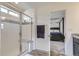 Bathroom showing glass shower with tiled walls, seat and door open to primary bedroom at 6233 N Liverpool St, Aurora, CO 80019
