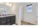 Bathroom vanity featuring dark cabinetry, granite countertop, and modern fixtures at 6233 N Liverpool St, Aurora, CO 80019