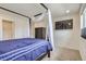 Bright bedroom featuring a four-poster bed, mounted TV, and closet access at 6233 N Liverpool St, Aurora, CO 80019
