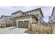 This home features a tan and brown exterior, garage, and sidewalk at 6233 N Liverpool St, Aurora, CO 80019