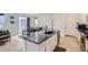 Open-concept kitchen with island, stainless steel appliances, and seamless flow into adjacent living and dining areas at 6233 N Liverpool St, Aurora, CO 80019