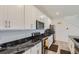 Updated kitchen features white cabinets, stainless steel appliances, and elegant black countertops for a modern look at 6233 N Liverpool St, Aurora, CO 80019