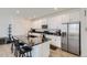 Modern kitchen boasts sleek white cabinets, stainless steel appliances, and a striking black marble countertop island at 6233 N Liverpool St, Aurora, CO 80019