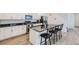 Stylish kitchen featuring white cabinetry, stainless steel appliances, and a center island with barstool seating at 6233 N Liverpool St, Aurora, CO 80019