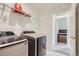 Efficient laundry room with modern washer and dryer units and convenient shelving at 6233 N Liverpool St, Aurora, CO 80019