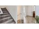 Bright entryway featuring a staircase with carpeted steps and luxury vinyl plank flooring at 6233 N Liverpool St, Aurora, CO 80019
