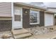 Close-up of the front entrance, highlighting the brickwork, a window and front door at 2311 E 96Th Way, Thornton, CO 80229