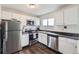 A compact, galley-style kitchen features stainless steel appliances and white cabinets at 2311 E 96Th Way, Thornton, CO 80229