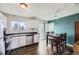 An eat-in kitchen features wood floors, white cabinets and an adjacent dining area at 2311 E 96Th Way, Thornton, CO 80229