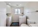 Bright laundry room features front load washer and dryer, wooden floors, a window, and ample storage at 2311 E 96Th Way, Thornton, CO 80229