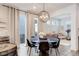 Elegant dining area with a round table, modern chandelier, and large windows providing ample natural light at 431 Courtfield Way, Castle Pines, CO 80108