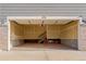 Empty two-car garage with stairs leading to another level and walls awaiting finishing at 431 Courtfield Way, Castle Pines, CO 80108
