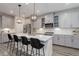 Elegant kitchen with gray cabinets, white countertops, and black bar stools at 431 Courtfield Way, Castle Pines, CO 80108