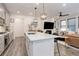 Bright kitchen island with seating overlooks living area with modern fireplace at 431 Courtfield Way, Castle Pines, CO 80108