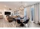 Open-concept living space with a stylish dining area featuring a modern chandelier and a comfortable living room with a fireplace at 431 Courtfield Way, Castle Pines, CO 80108