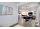 Open-concept living space with hardwood floors, a dining area, and a glimpse into the modern kitchen at 431 Courtfield Way, Castle Pines, CO 80108